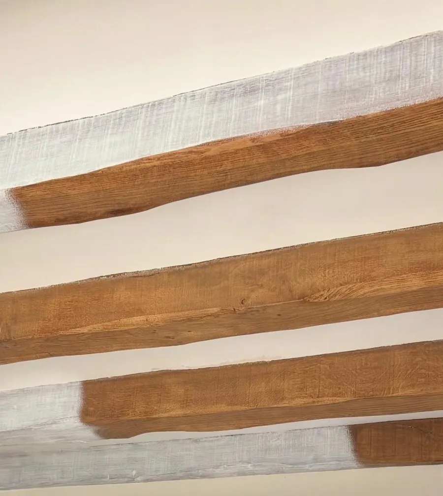 Poutres en chêne à moitié décapées : peinture blanche d’un côté, bois nu de l’autre