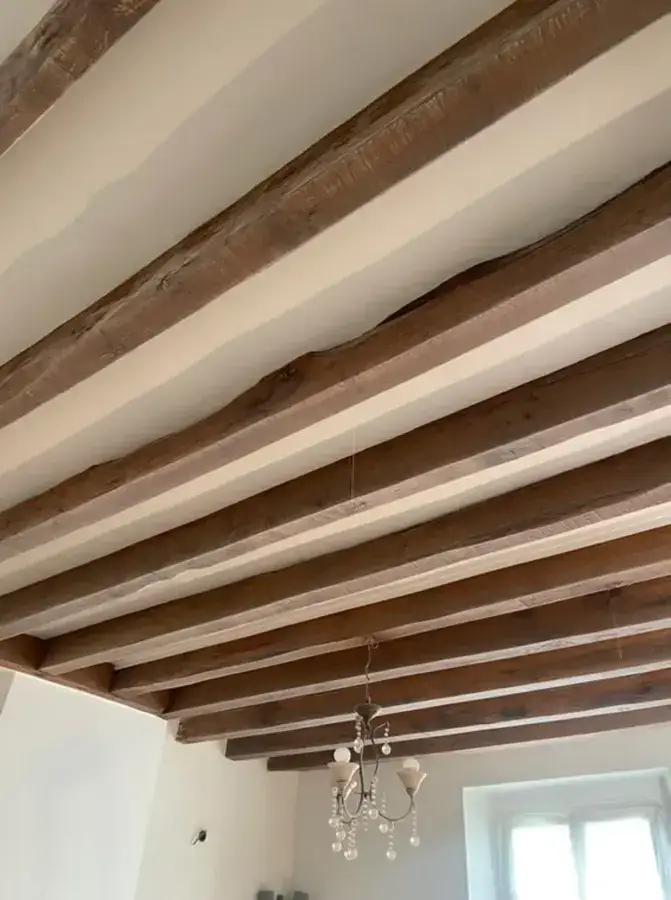 Poutres en chêne décapées par aérogommage dans une maison